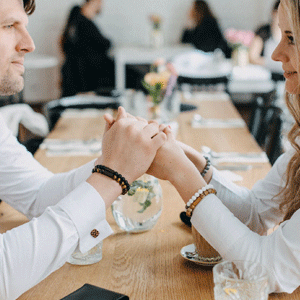 Ein Paar sitzt sich gegenüber und trägt Armbänder